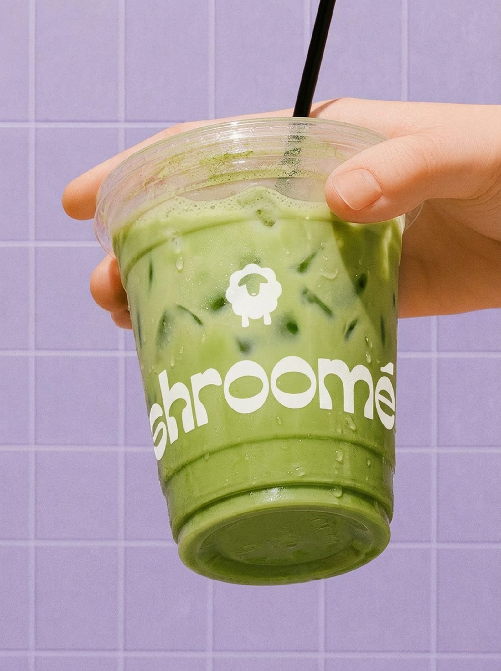 Iced shroomé matcha latte in a branded cup