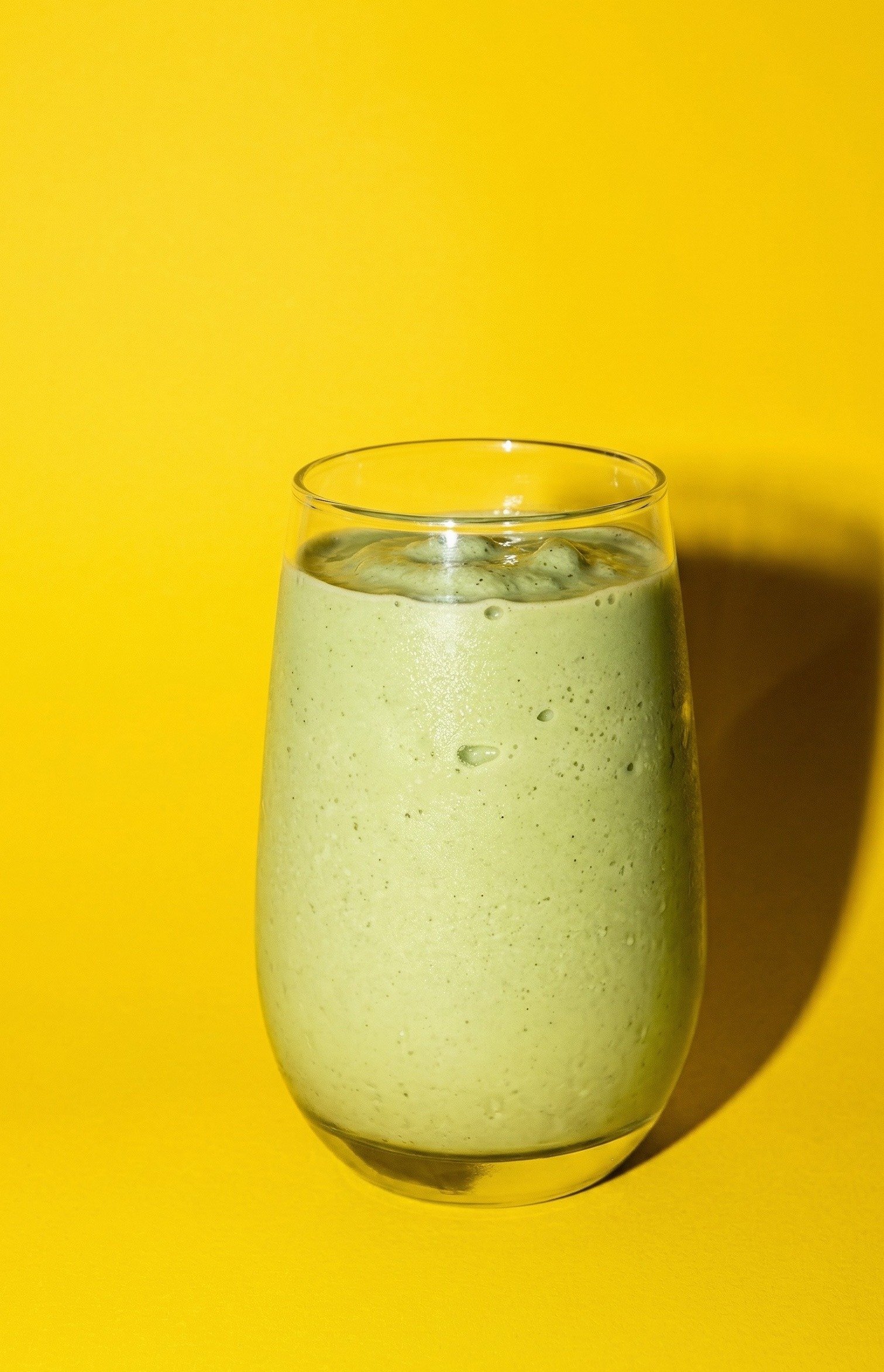 Vanilla Matcha Smoothie — thick creamy green smoothie with frozen banana in a stemless glass